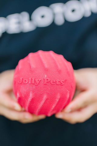 Caitlin Holding The Jolly Tuff Tosser Ball With The Logo Out