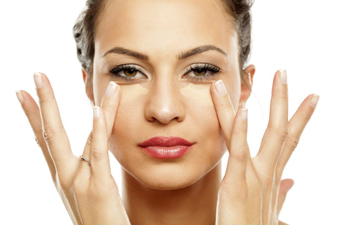 woman applying under eye concealer