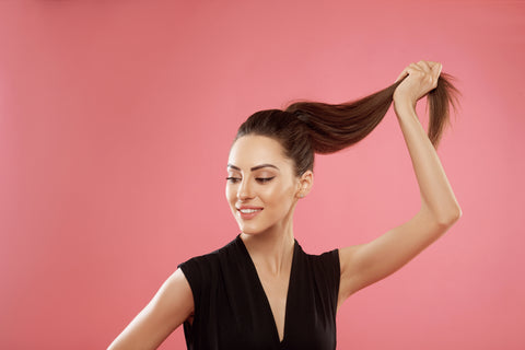 woman holding up hair by her ponytail