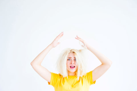 woman upset and throwing arms above her head because she has bad hair