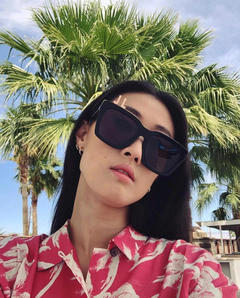 Fashion Director and Stylist Justine Lee  wears REVÉ by RENÉ Alphabet Bar Sunglasses and Gold Plated Letters. 
