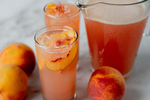 Peach and beer cocktail in glasses and a pitcher
