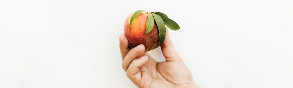 Hand holding a peach