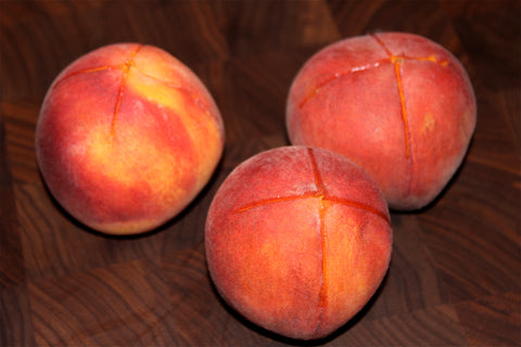 Peaches with an X cut in their skin