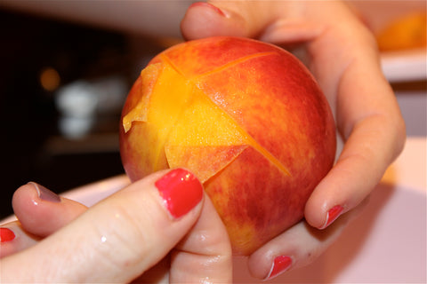 Skin being peeled off of a peach
