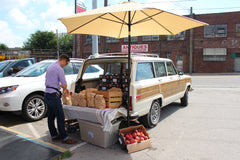 A station wagon selling peaches out of its trunk