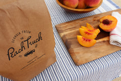 Peaches being sliced on a cutting board for a picnic