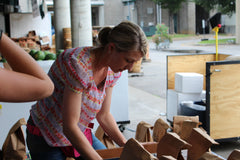 Woman choosing her bag of peaches from a table