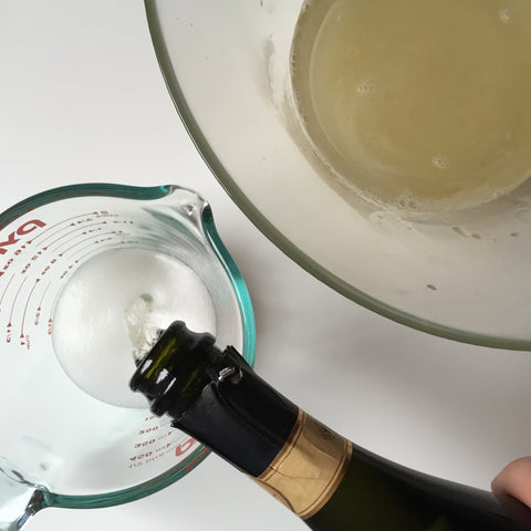 Using a measuring cup to pour champagne
