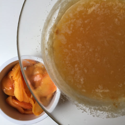 The champagne mixture in a bowl next to the sliced peaches