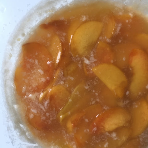 Peach slices added within the champagne mixture