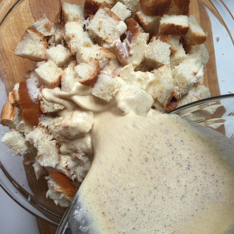 The ingredient mixture being poured over top of the bread