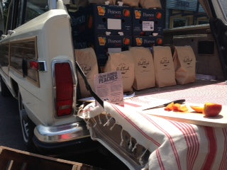 Peach produce and goods loaded into the back of a truck