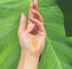 a hand with full spectrum hemp oil dripping down its wrist