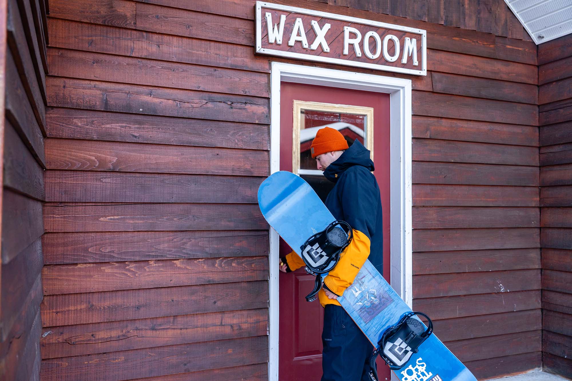 Male snowboarder entering a wax room