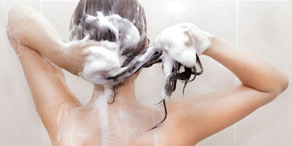 kvinde vasker sit hår