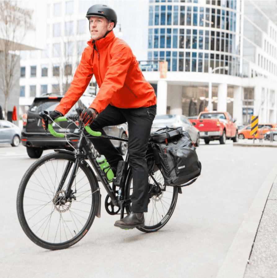 Man riding bike in the city with Two Wheel Gear Garment Pannier Classic 3.0 on pannier rack.