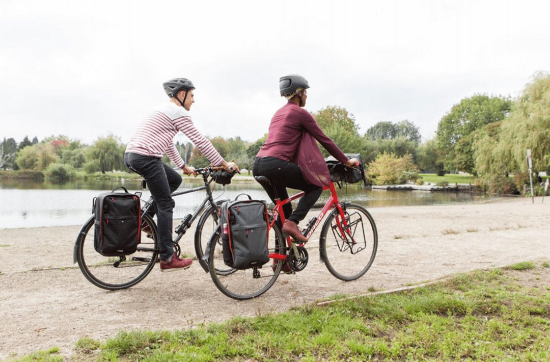 A couple riding their bikes, geared up with Two Wheel Gear bags