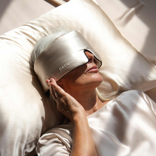 Model sleeping with a Drowsy rouge coloured silk sleep mask covering her eyes