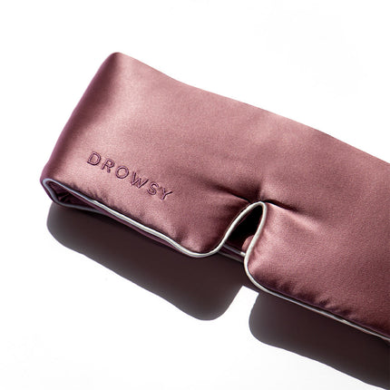 A Drowsy pink silk sleep mask on a white background