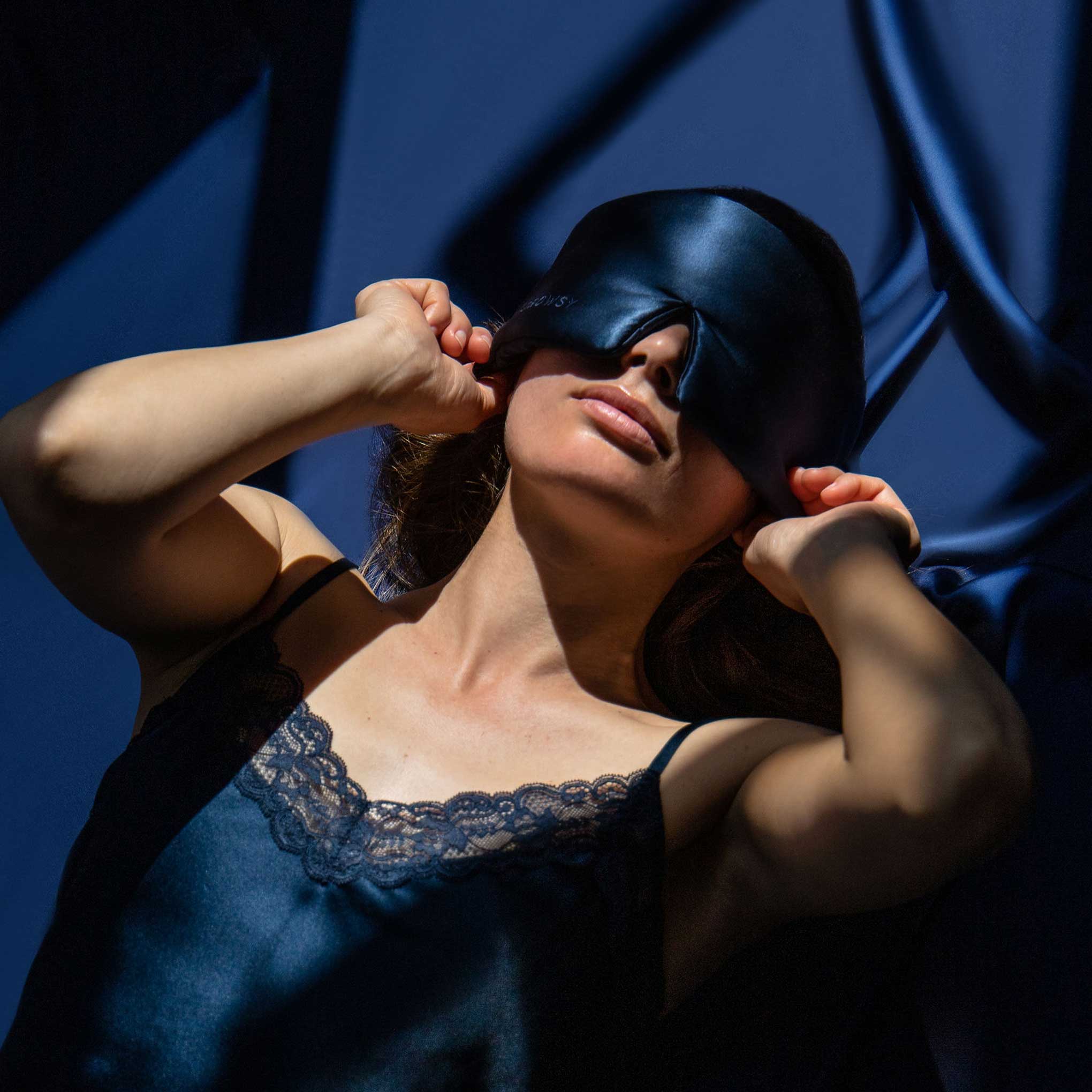 Model sleeping with a Drowsy blue silk sleep mask covering her eyes