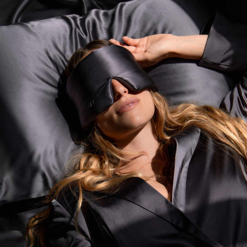Model sleeping with a Drowsy pink silk sleep mask covering her eyes
