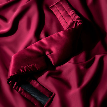 A Drowsy Rouge silk sleep mask with a silk background