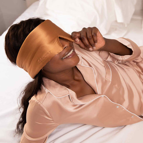 Model sleeping with a Drowsy terracotta coloured silk sleep mask covering her eyes