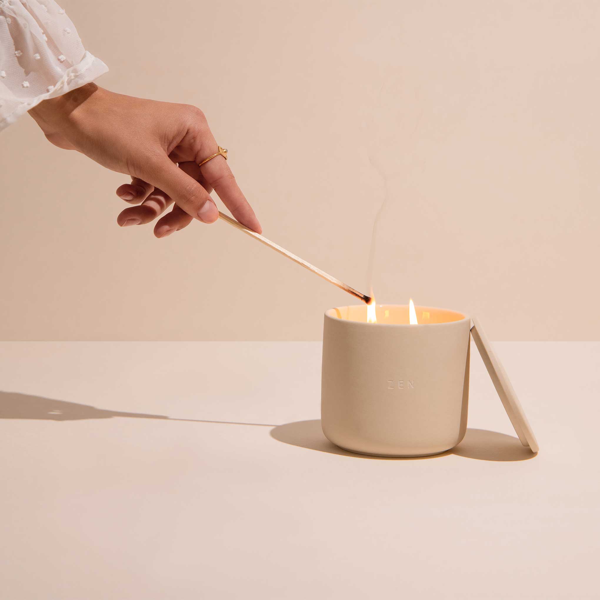 Hand lighting Drowsy Sleep Co. Sleep candle with a long match