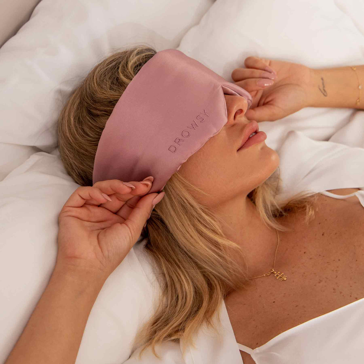 Sleeping model in bed with Drowsy silk sleep mask covering eyes