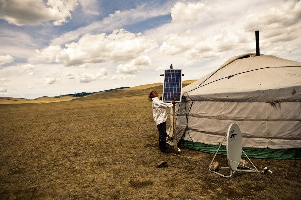 Timothy FadekA Mongolian horse herder adjusts a solar panel