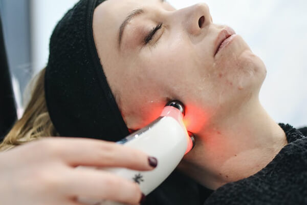 women undergoing laser treatment on her face