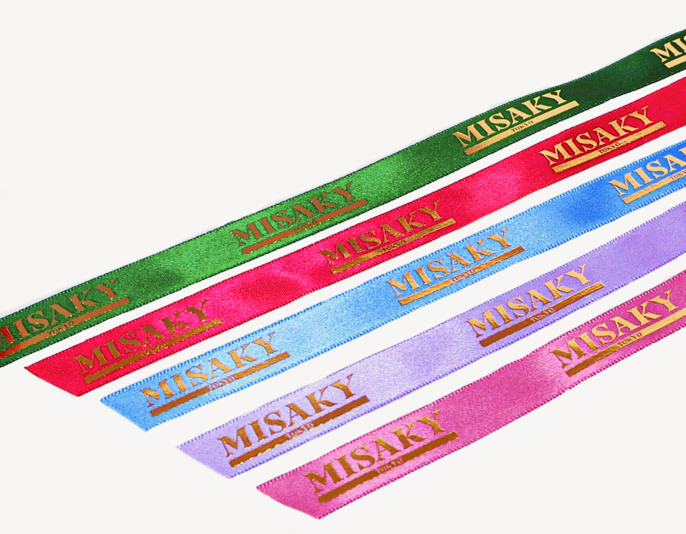 Four colorful satin ribbons arranged diagonally on a white background, each with 'MISAKI' printed in gold letters. From top to bottom, the ribbons are green, red, blue, and pink.