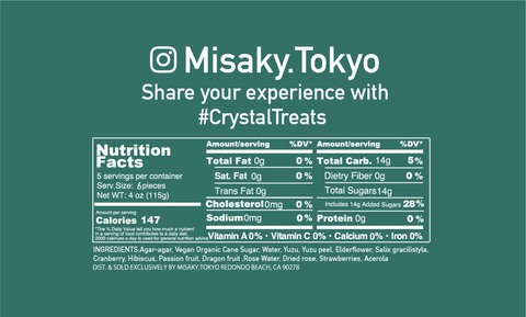 The image is a nutritional facts label for a product from Misaky.Tokyo, inviting customers to share their experience with the hashtag #CrystalTreats. It details that the serving size is 2 pieces (28g), and there are 5 servings per container. Each serving contains 372 calories and provides 0g of total fat, saturated fat, trans fat, cholesterol, sodium, and protein, which all account for 0% of the daily value (DV). The total carbohydrate content is 93g per serving, which is 33% of the DV, including 0g of dietary fiber and 33g of total sugars (with 33g added sugars), making up 36% of the DV.  The ingredients listed are organic dragon fruit, passion fruit, yuzu, vegan organic hibiscus, organic cranberry, and edible gold.  The product is distributed and sold exclusively by Misaky.Tokyo, with an address provided at the bottom of the label: 2617 Manhattan Beach Blvd, Redondo Beach, CA 90278.