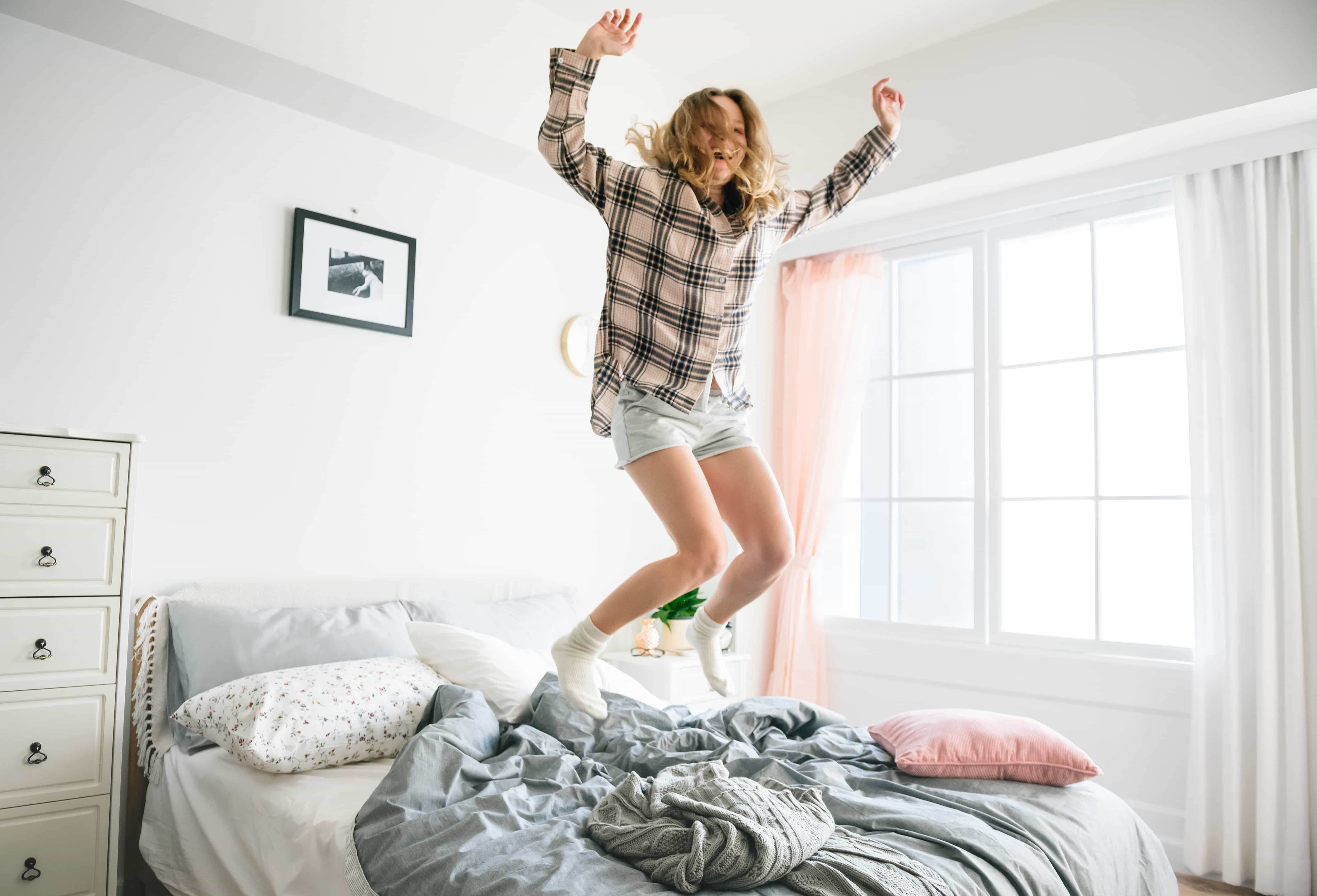 Woman jumping on a bed