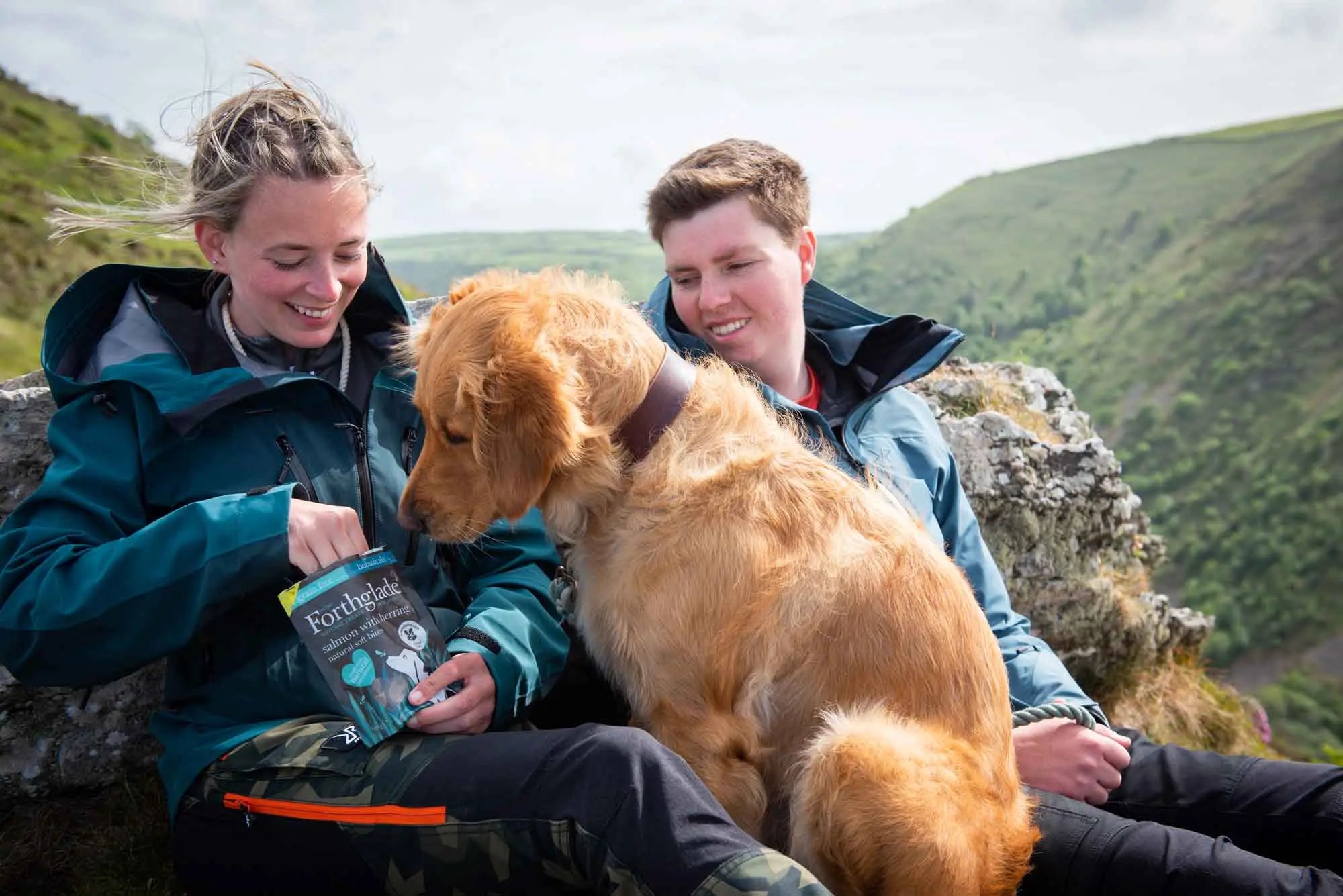 Woman and man giving a dog a treat