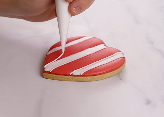 Heart shaped cookie being iced