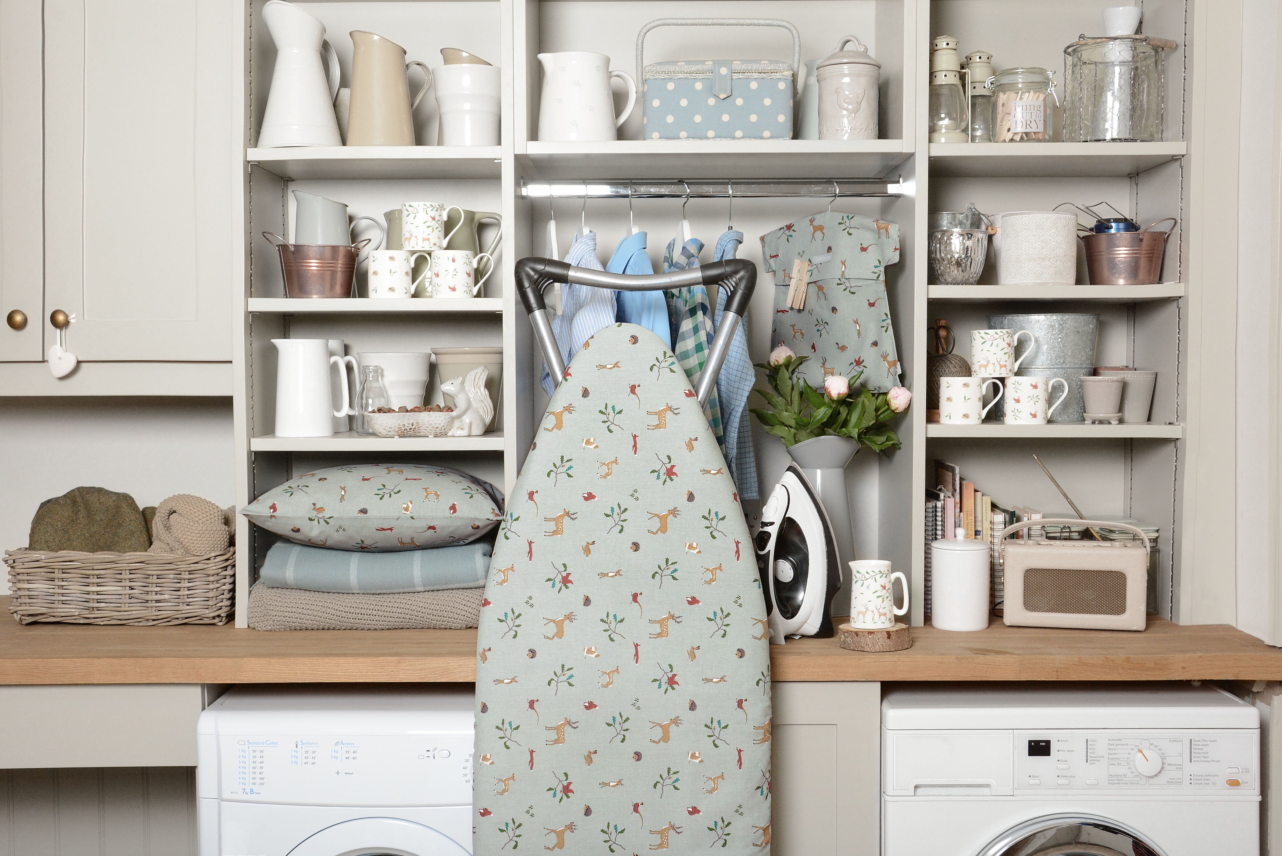Utility room with ironing board and woodland homeware linens