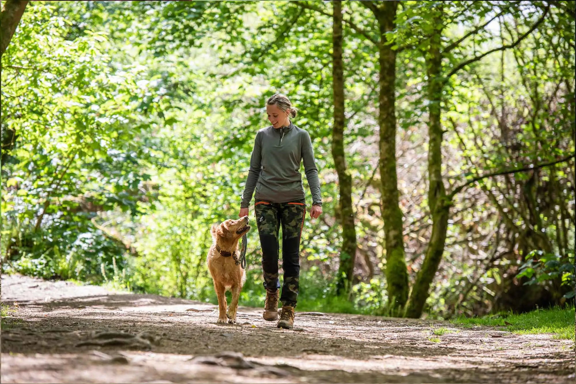 Woman walking her dog in the woods 