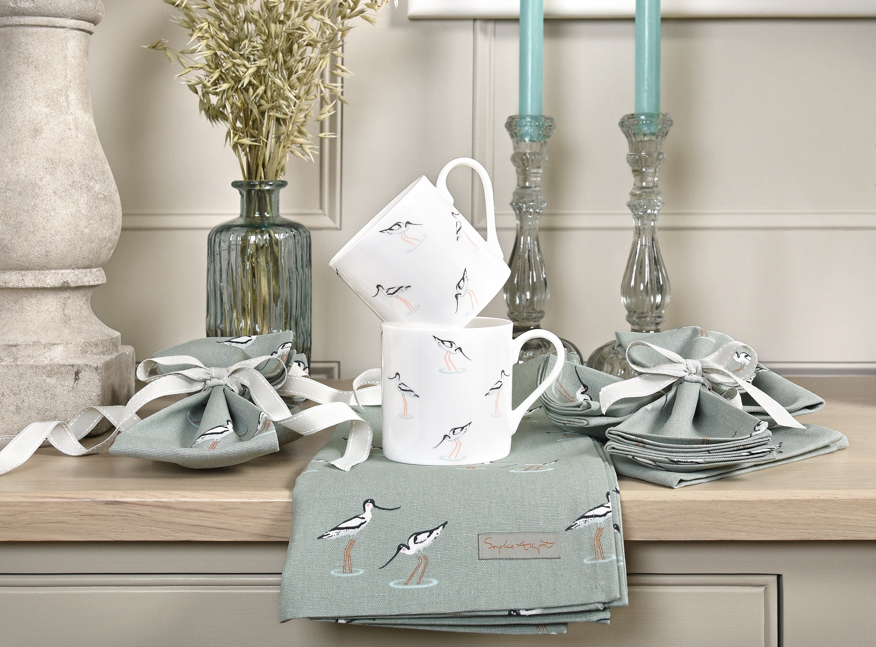 Sophie Allport's avocets mugs stacked up on a beautiful dresser