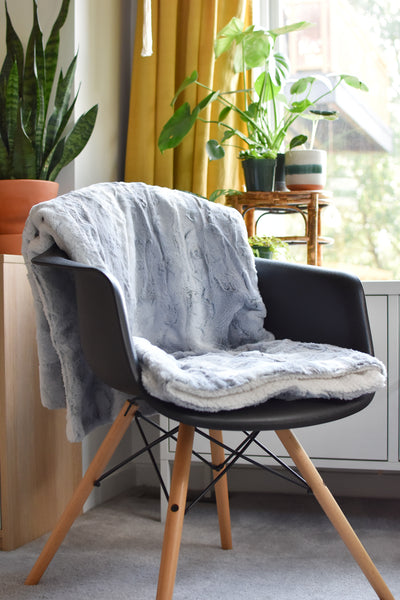 folded blanket laid over seat and back of chair