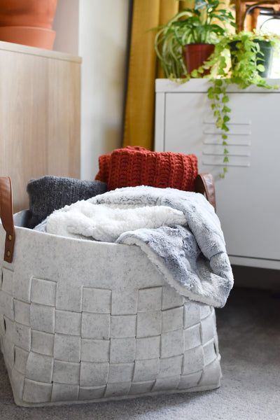 blankets folded in a grey basket