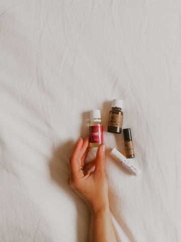 Photo of someone holding bottles of different essential oils.