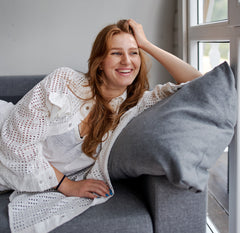 Woman smiling while lounging on a sofa