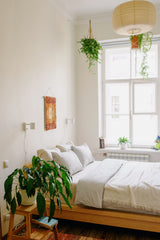 Photo of a bed in a bedroom surrounded by house plants