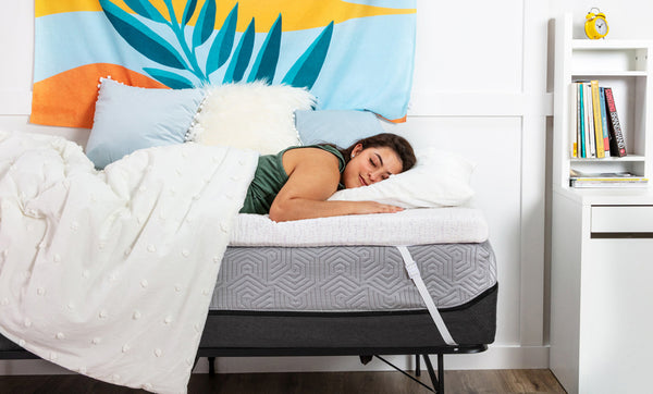 College student sleeping on a Viscosoft Select High Density mattress topper in a dorm room
