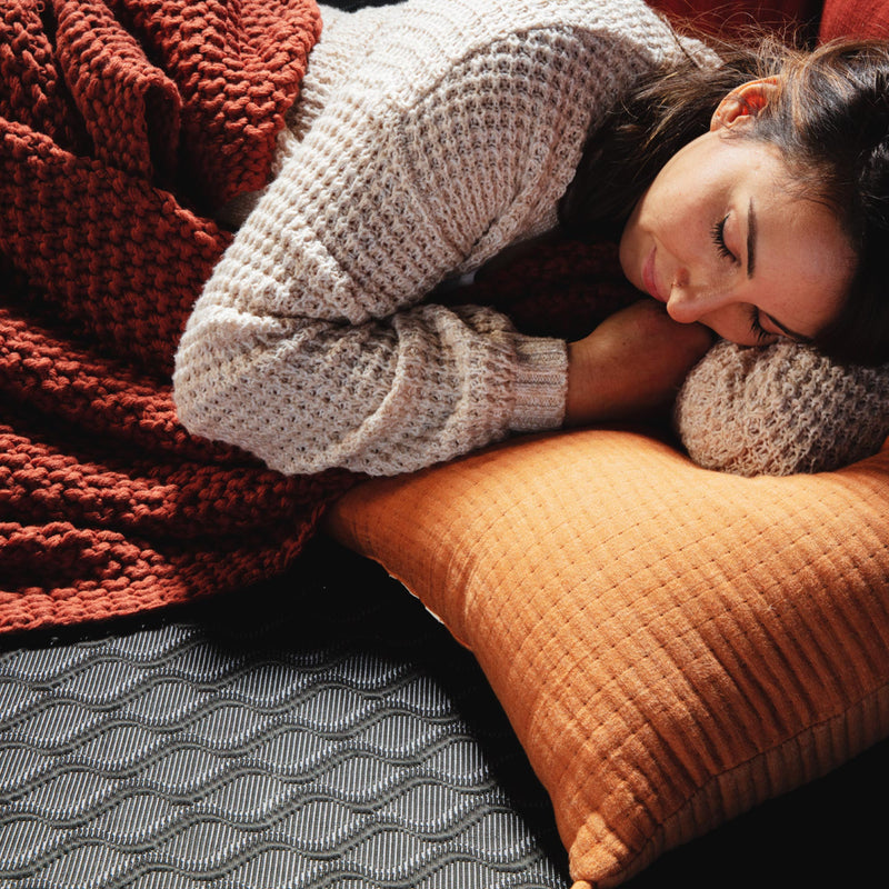 一个女人睡在黑色活跃的冷却床垫上的照片。