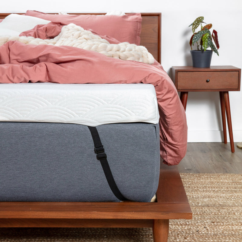 象牙活跃的冷却床垫套装的特写景色安装在床上，顶部有舒适的床上用品。