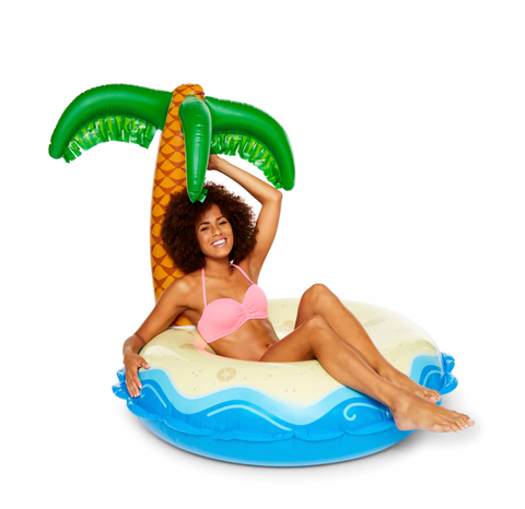 woman sitting in a giant inner tub pool float that looks like a palm tree