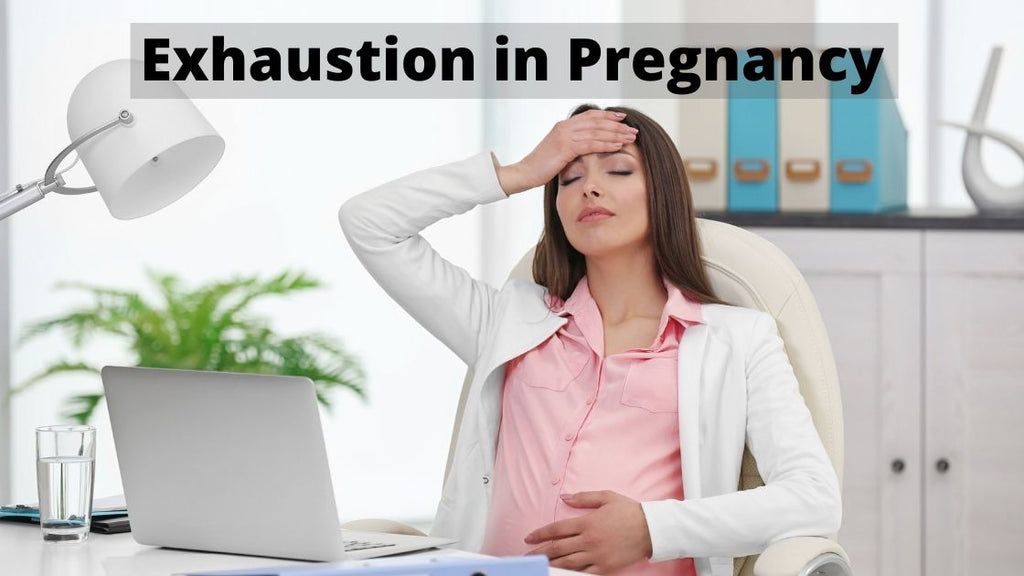tired pregnant woman at her desk